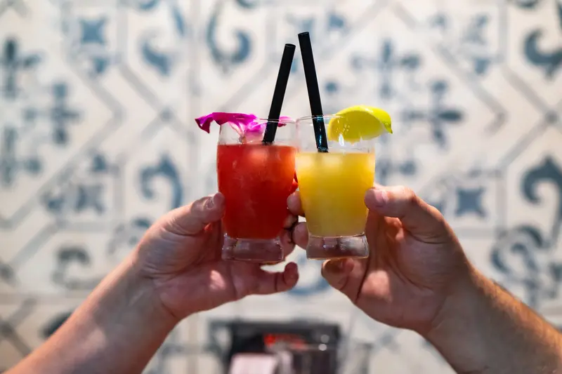 Two cocktails toasting over Talavera tile at Viva Leawood