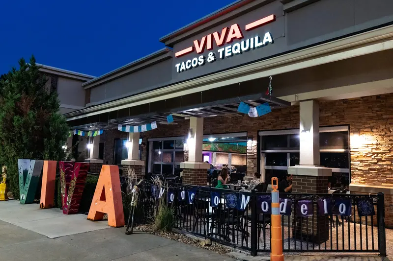 The Viva Leawood storefront at dusk with the big VIVA letters on the patio