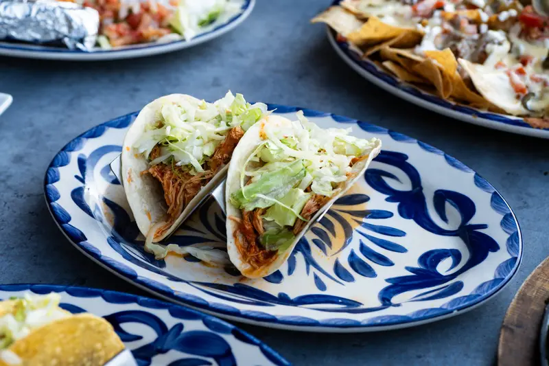 Soft tacos on a blue Talavera plate at Viva Leawood