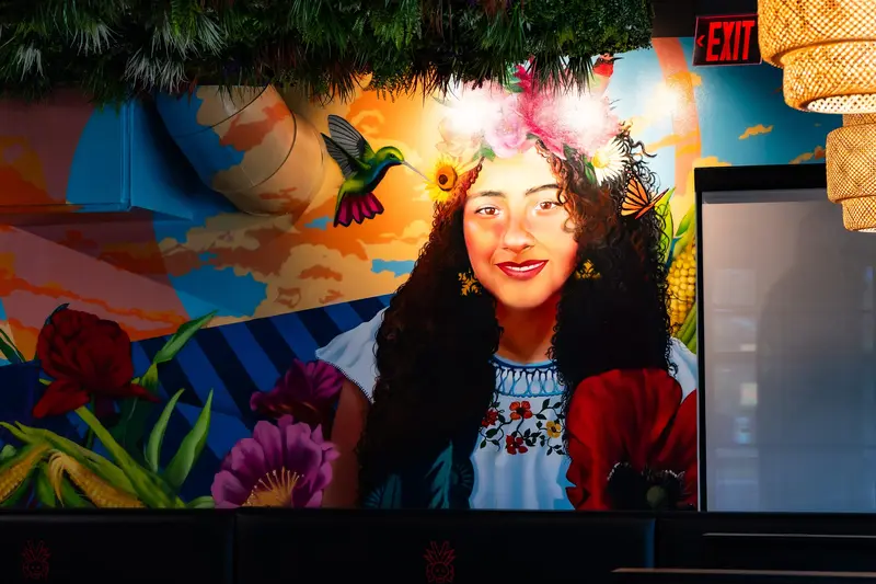 Mural of a woman in a flower crown with a hummingbird at Viva Olathe