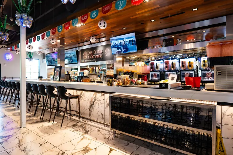 The long marble bar at Viva Olathe with the frozen margarita machines