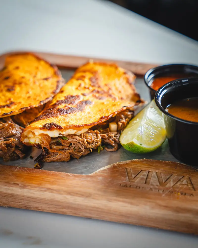 Quesabirria with a cup of consome on a VIVA board
