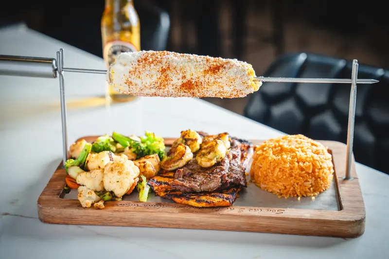 The Steak Patron board with an elote skewer at Viva Wichita